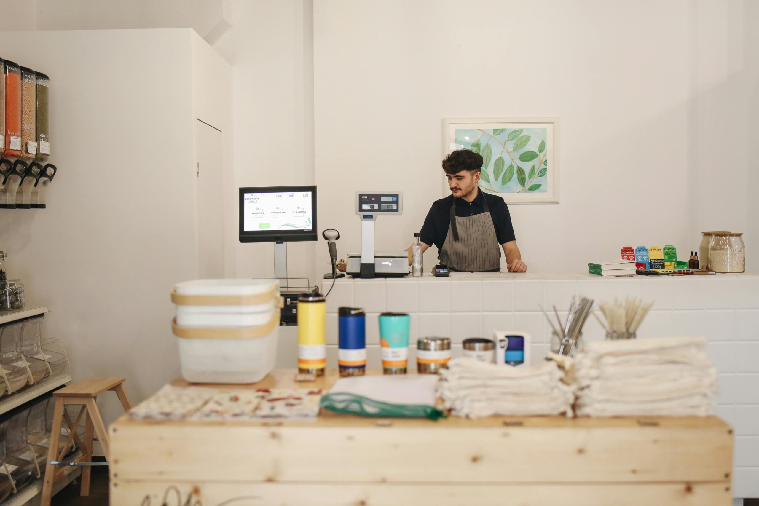 Mitarbeiter eines Unverpackt-Ladens mit Produktangebot für nachhaltigen Einkauf ohne Verpackungsmüll