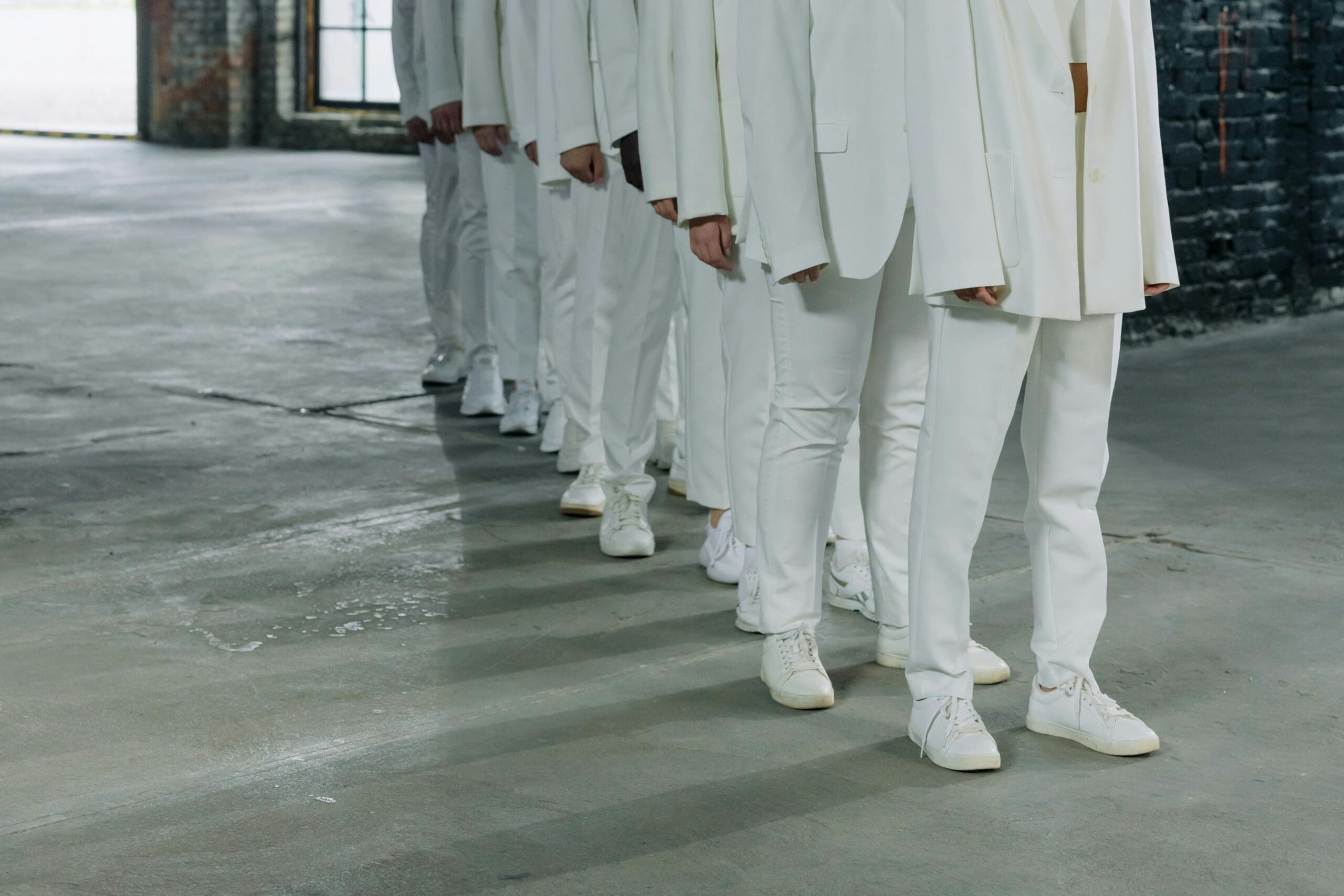 Kollektion weißer Veja-Sneaker getragen von Models in einer Modenschau, zeigt die Verbindung von ethischer Produktion und zeitlosem Design bei nachhaltigen Schuhen