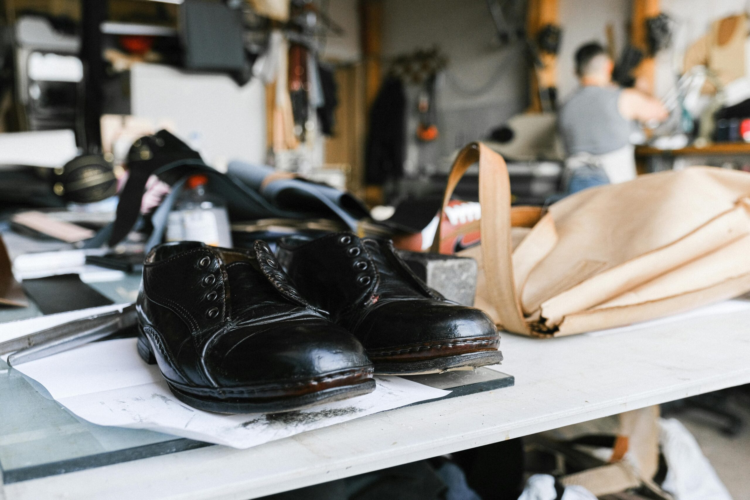 Handwerkliche Schuhfertigung in einer traditionellen Werkstatt - schwarze Lederschuhe werden nach ökologischen Standards gefertigt und repariert
