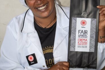 Solino Coffee Mitarbeiterin in Äthiopien präsentiert die Fair Wandel Crema Verpackung - Beispiel für qualifizierte Arbeitsplätze durch lokale Wertschöpfung