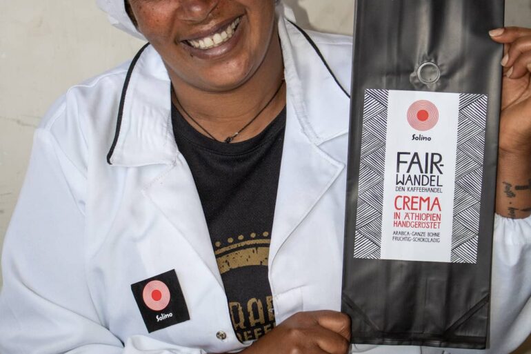 Solino Coffee Mitarbeiterin in Äthiopien präsentiert die Fair Wandel Crema Verpackung - Beispiel für qualifizierte Arbeitsplätze durch lokale Wertschöpfung